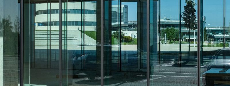 A vertical shot of the transparent doors of a commercial building